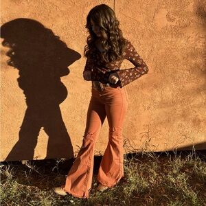 Mid-rise deep orange flare jeans with ripped knees